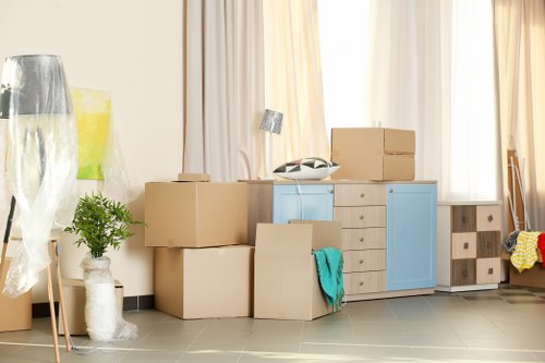 Van removal team carrying furniture in a Lambeth flat move